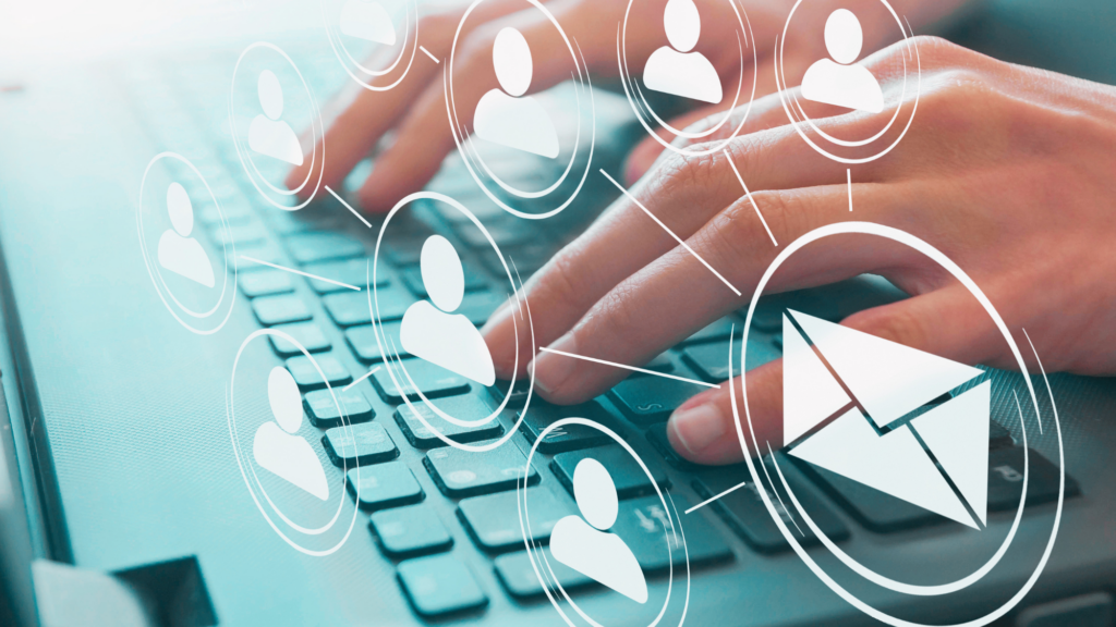 Fingers at a keyboard, typing emails to a list of potential sales leads.