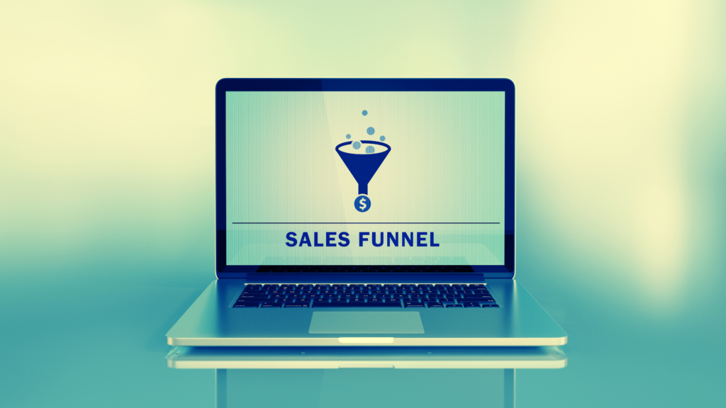 An open laptop computer with the words "sales funnel" and a graphic on the screen.
