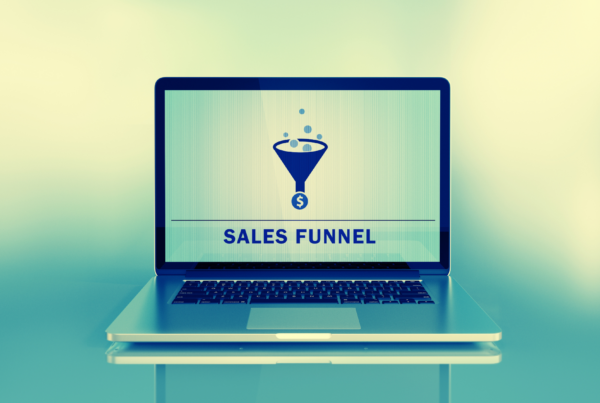 An open laptop computer with the words "sales funnel" and a graphic on the screen.