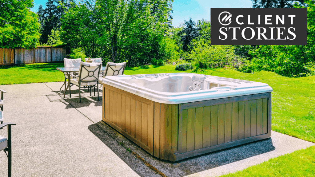 Hot tub on a patio in a grassy backyard.