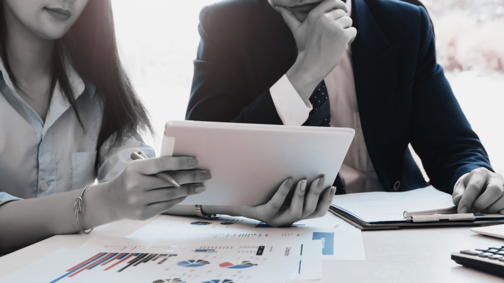 Two business professionals sitting at a table going over data.