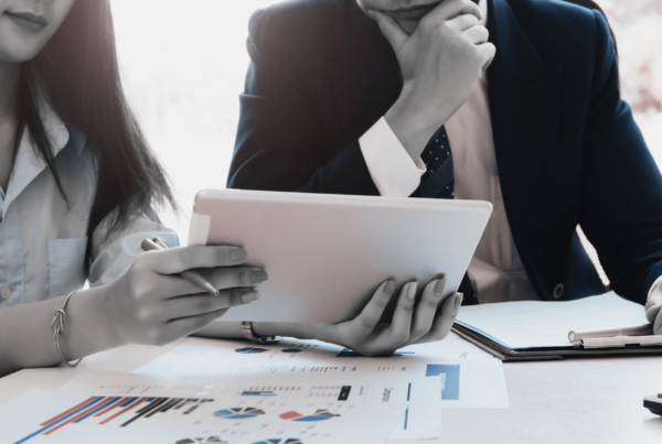 Two business professionals sitting at a table going over data.