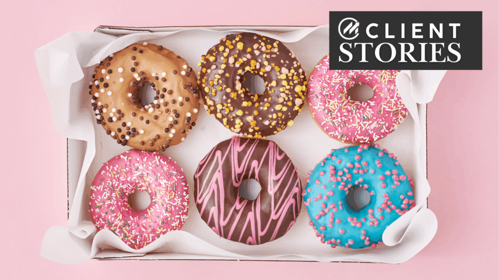 Six tasty-looking frosted donuts in a tissue-lined box.