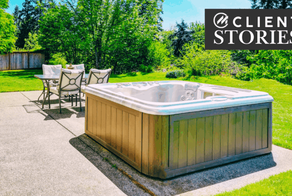 Hot tub on a patio in a grassy backyard.